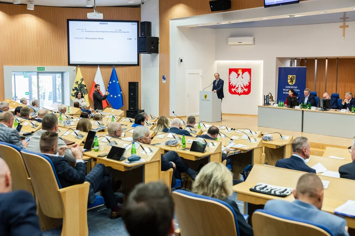 Posiedzenie sejmiku województwa pomorskiego w sali plenarnej z mówcą przy pulpicie i radnymi przy biurkach.